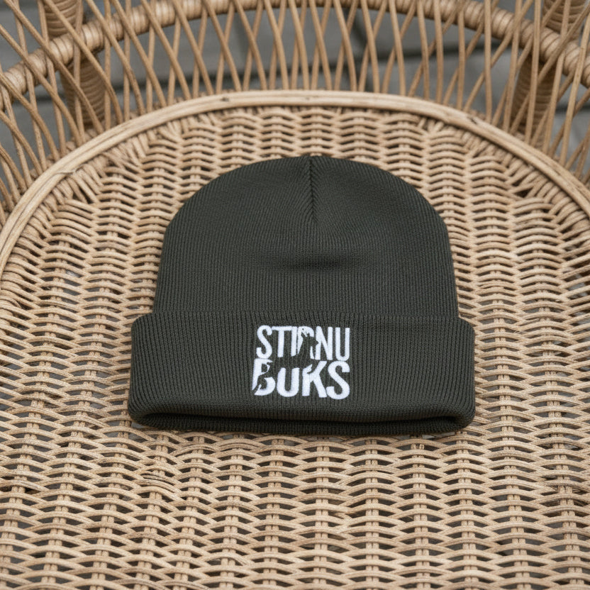 Gray beanie with 'STIRNU BUKS' text on a green leafy background