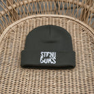 Gray beanie with 'STIRNU BUKS' text on a green leafy background